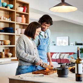 A couple cooking together in the kitchen in order to help their feelings of being distanced from eac...