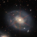 一个正面的星系,灰色的旋臂,撒上明亮的恒星形成红色斑块。ce…
