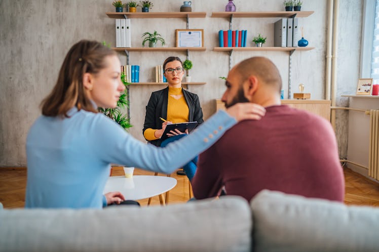 Couple sitting on couch during therapy session as therapist looks on