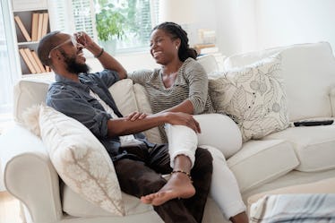 Couple sitting together on a couch, talking and laughing