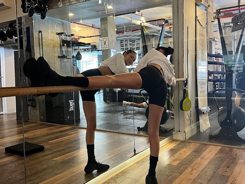 Bella Hadid does a full body workout routine at the gym with leg stretches. 