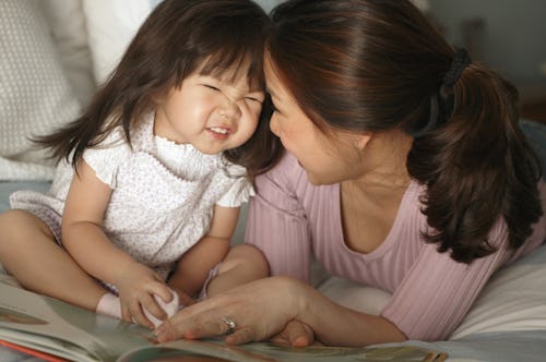 mom reading book to little girl