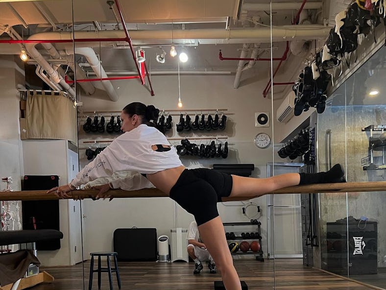 At the gym, Bella Hadid does a leg workout routine with leg exercises. 