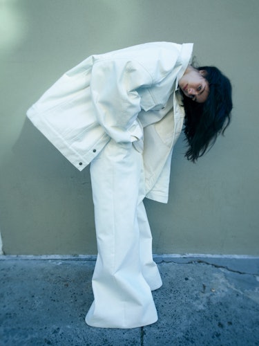 Model Loli Bahia wearing white jean jacket and white pants.