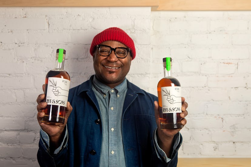 André Mack holds two bottles of Rye & Sons whiskey.