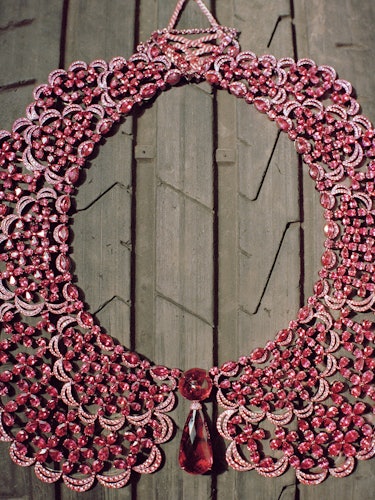 an elaborate ruby necklace laid on top of a tire's treads