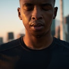 Close up of a man outside taking a second to reflect.