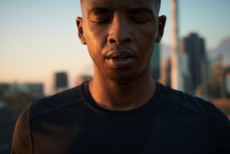 Close up of a man outside taking a second to reflect.