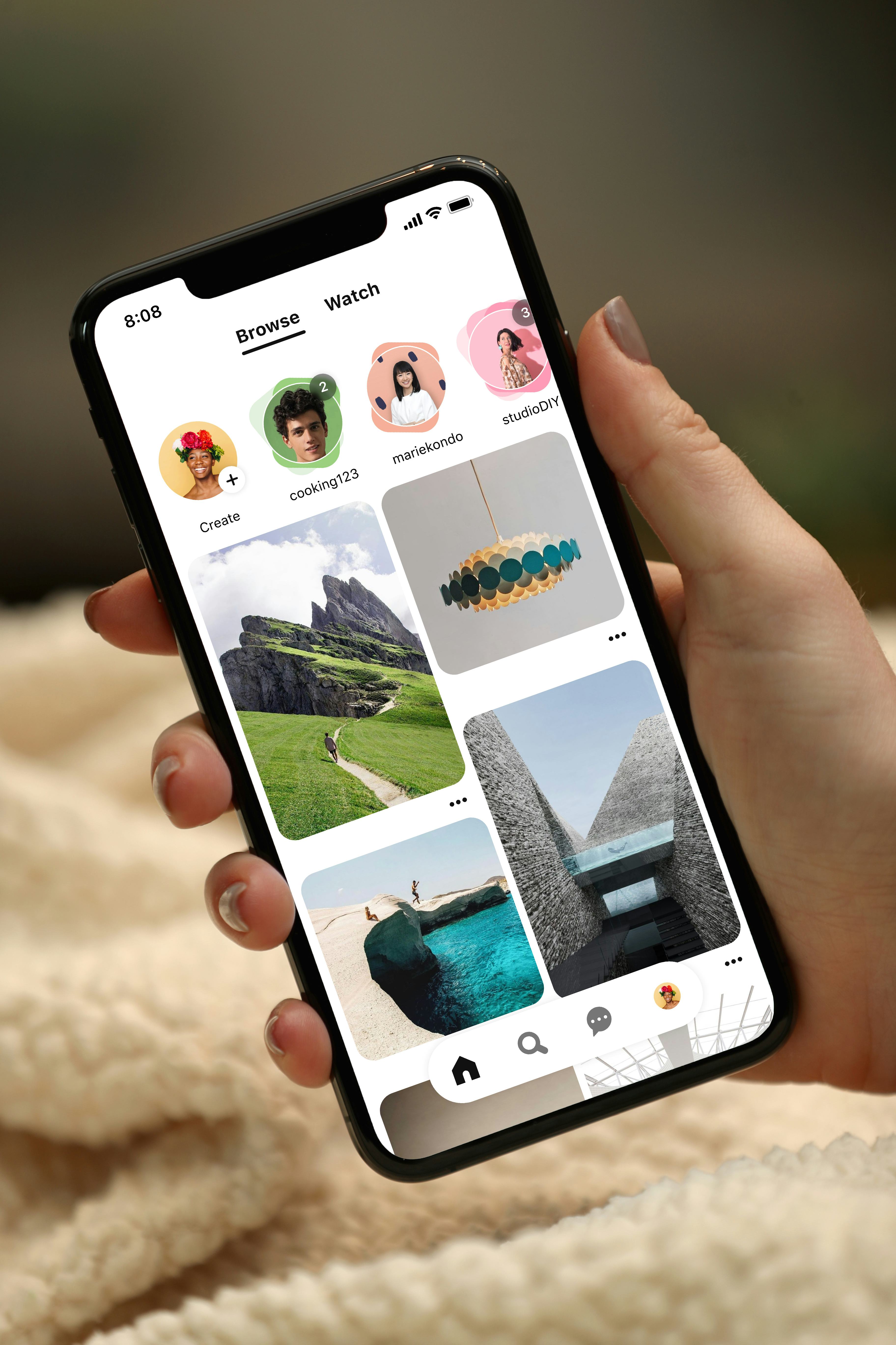 A hand holding a cell phone with Pinterest's app on the screen, in a list of 2023 Pinterest trends