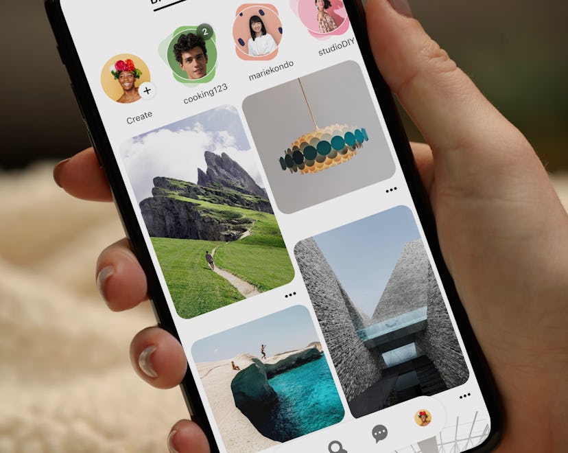 A hand holding a cell phone with Pinterest's app on the screen, in a list of 2023 Pinterest trends