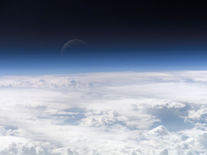 color photo of the upper bounds of Earth's atmosphere fading into the dark of space