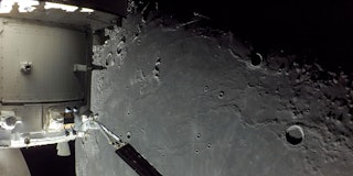 A portion of the far side of the Moon looms large just beyond the Orion spacecraft in this image tak...