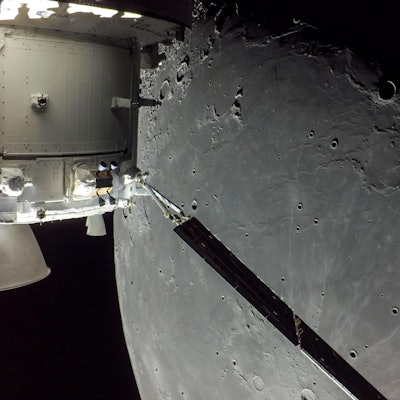 A portion of the far side of the Moon looms large just beyond the Orion spacecraft in this image tak...