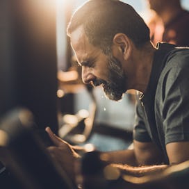 A pained man working out on an exercise bike.