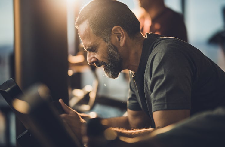 A pained man working out on an exercise bike.