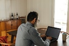 一个戴眼镜的男人在电脑前工作。