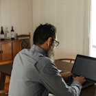 A man wearing glasses working at his computer.