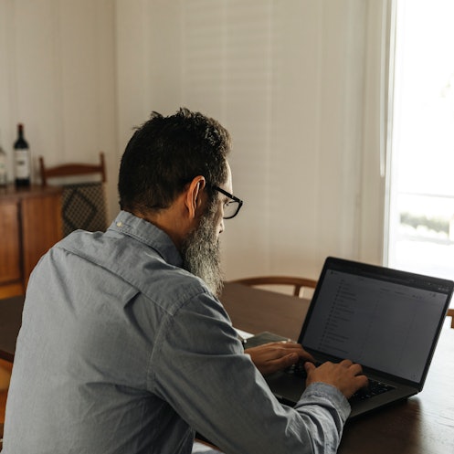 一个戴眼镜的男人在电脑前工作。