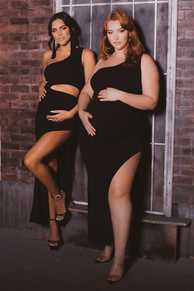Two models in black floor length new year's maternity dresses with cut out details