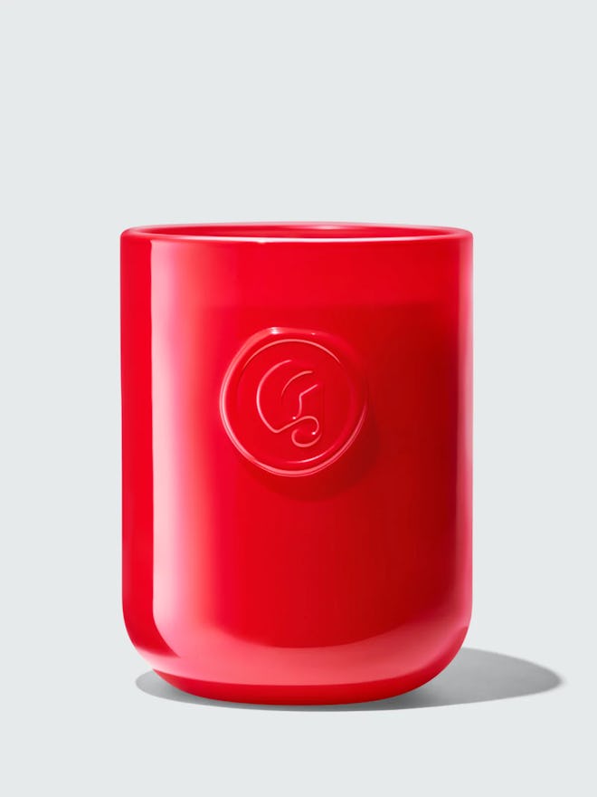 Red glass candle with Glossier's G logo emblazoned on the front