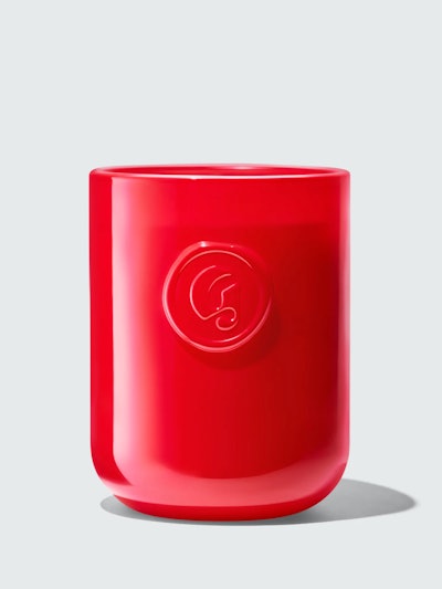 Red glass candle with Glossier's G logo emblazoned on the front