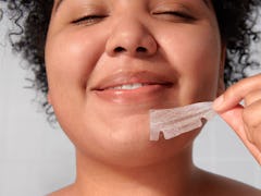 A woman rips off a Mighty Patch Chin pimple patch