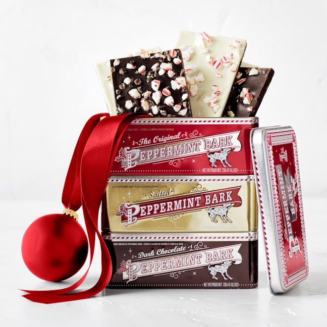 A stack of peppermint bark tins with bark spilling out