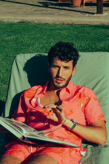 Sebastián Yatra in a salmon colored button down shirt