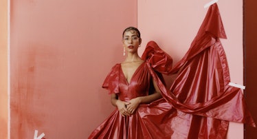 the gallerist and curator Hannah Traore wearing a red dress in a pink room