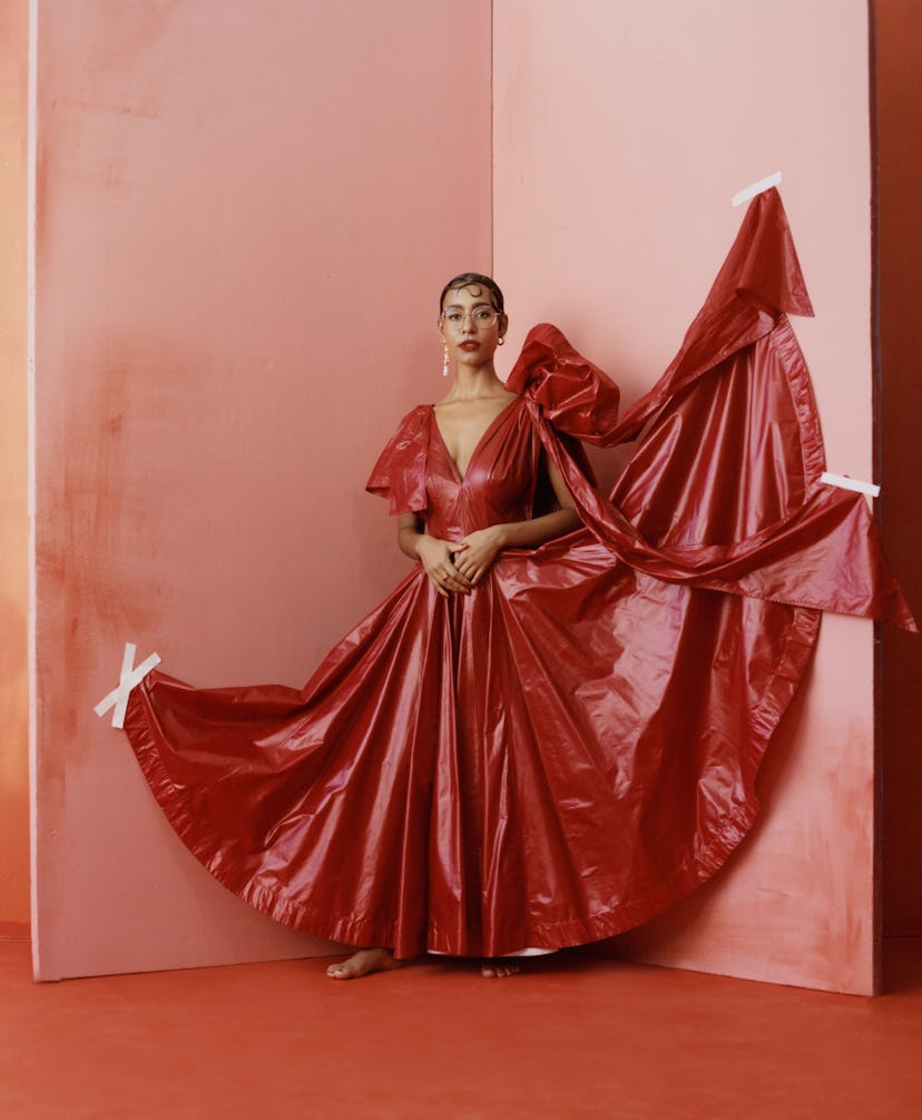 the gallerist and curator Hannah Traore wearing a red dress in a pink room
