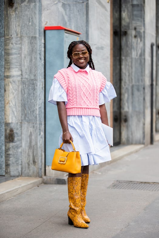 Young woman wearing the 2022 fashion trend: preppy sweater vest.