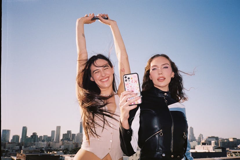 The sisters and Wildflower co-founders Sydney and Devon Lee Carlson posing together with a city view...