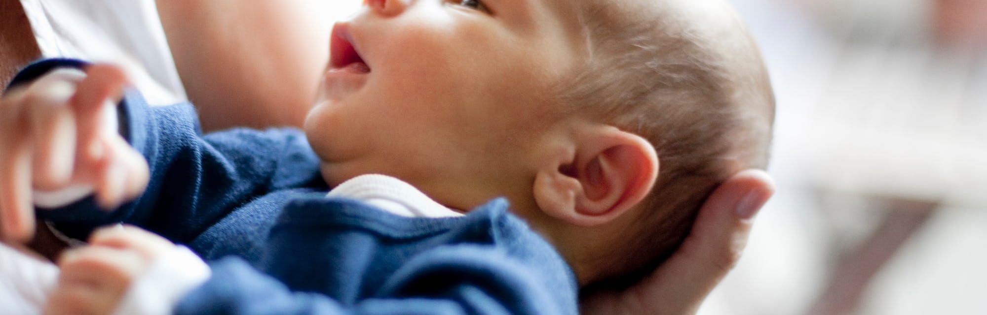 a blue cardigan and white onesie is a cute coming home outfit idea for baby boy