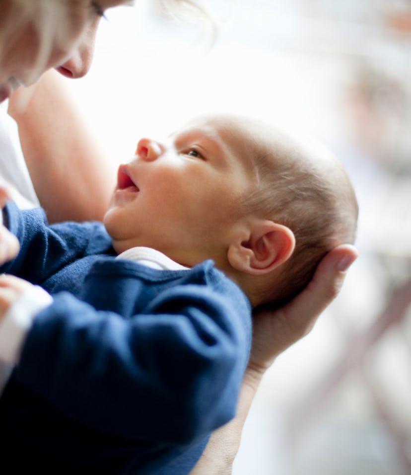 a blue cardigan and white onesie is a cute coming home outfit idea for baby boy