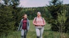 Two young women walking in the forest during the February 2022 full Snow Moon on Feb. 16, which will...