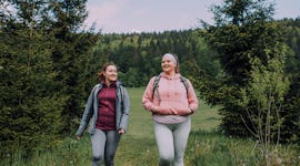 Two young women walking in the forest during the February 2022 full Snow Moon on Feb. 16, which will...