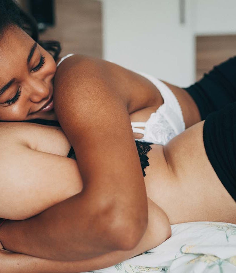 Two women lying in a bed and hugging while trying to get turned on, even though they are exhausted f...