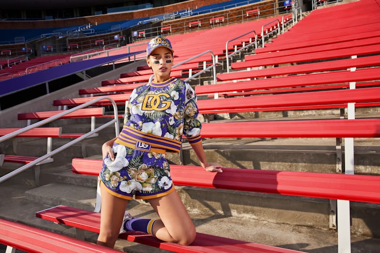Model wears Dolce & Gabbana look in stadium stands.