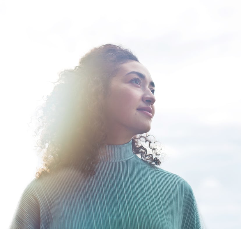 Young woman in sunlight, ready to find out the spiritual meaning of the February 2022 full Snow Moon...