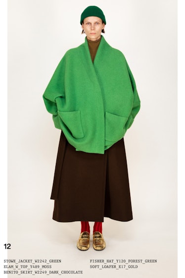 Model on the NY Fashion Week Fall 2022 in The Row oversized green jacket, brown skirt, red socks, an...
