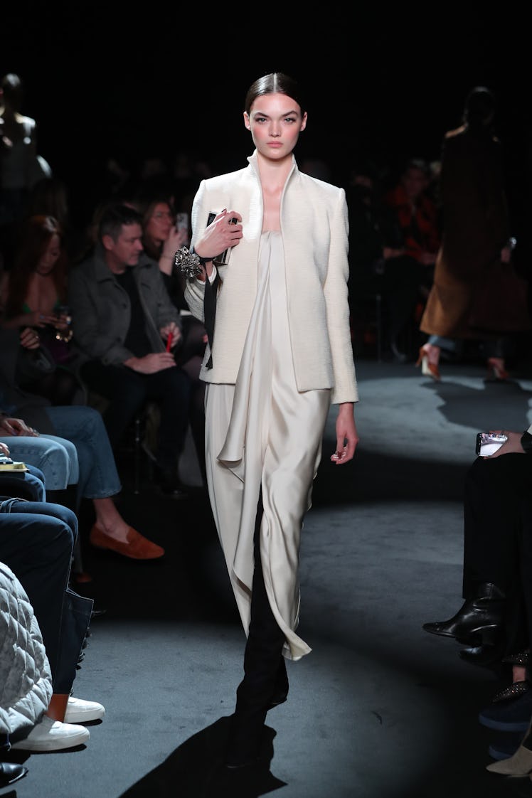 Model on the NY Fashion Week Fall 2022 runway in Brandon Maxwell beige silk dress with a beige suit ...