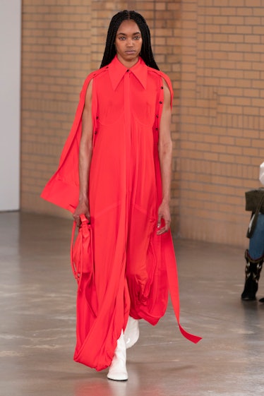 Model on the NY Fashion Week Fall 2022 in Proenza Schouler pink jumpsuit with a pink leather purse.