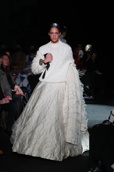 Model on the NY Fashion Week Fall 2022 runway in Brandon Maxwell white sweater and a white puffy dre...