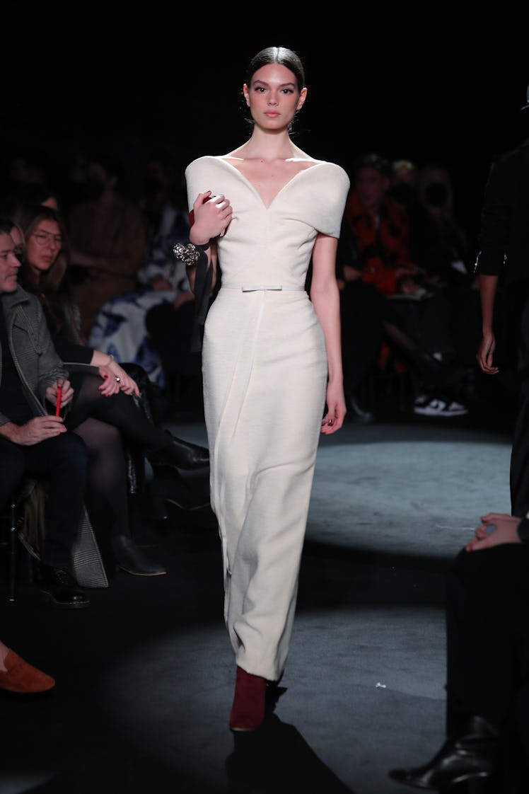 Model on the NY Fashion Week Fall 2022 runway in Brandon Maxwell off-white dress with red heels and ...