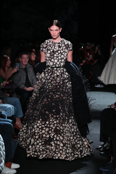 Model on the NY Fashion Week Fall 2022 runway in Brandon Maxwell black and brown dress with white ro...