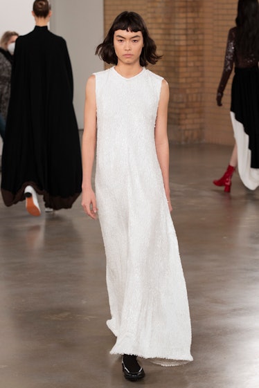 Model on the NY Fashion Week Fall 2022 in Proenza Schouler long white sleeveless dress.