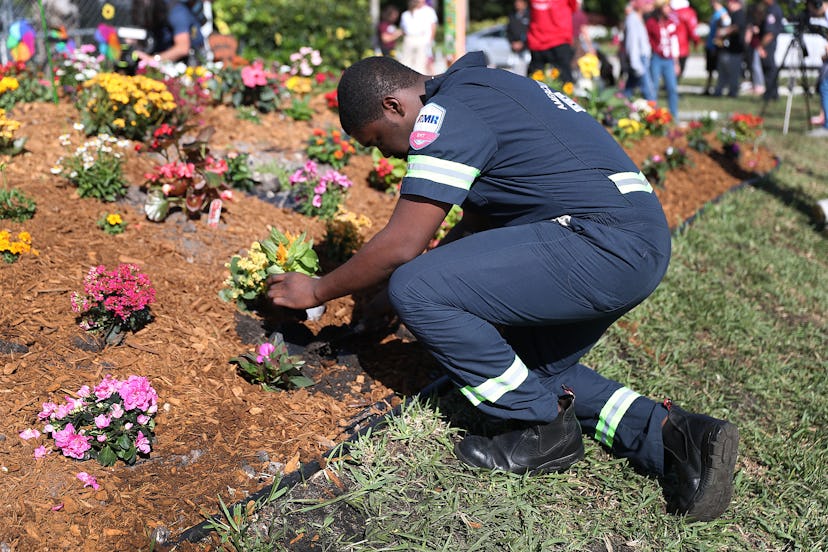 On Valentine’s Day 2019, Devon Fuller puts a plant in the ground at a garden setup in memory of thos...