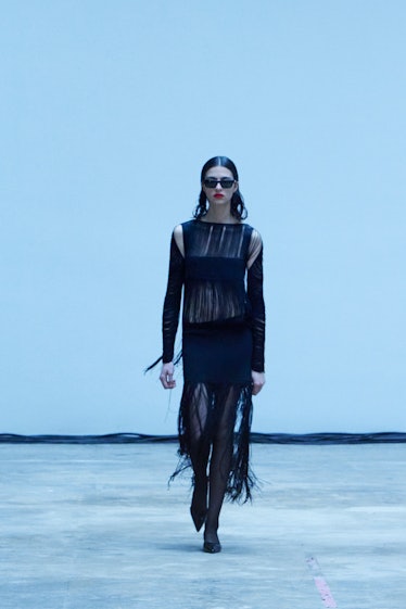 Model on the NY Fashion Week Fall 2022 runway in a Khaite black dress with rips