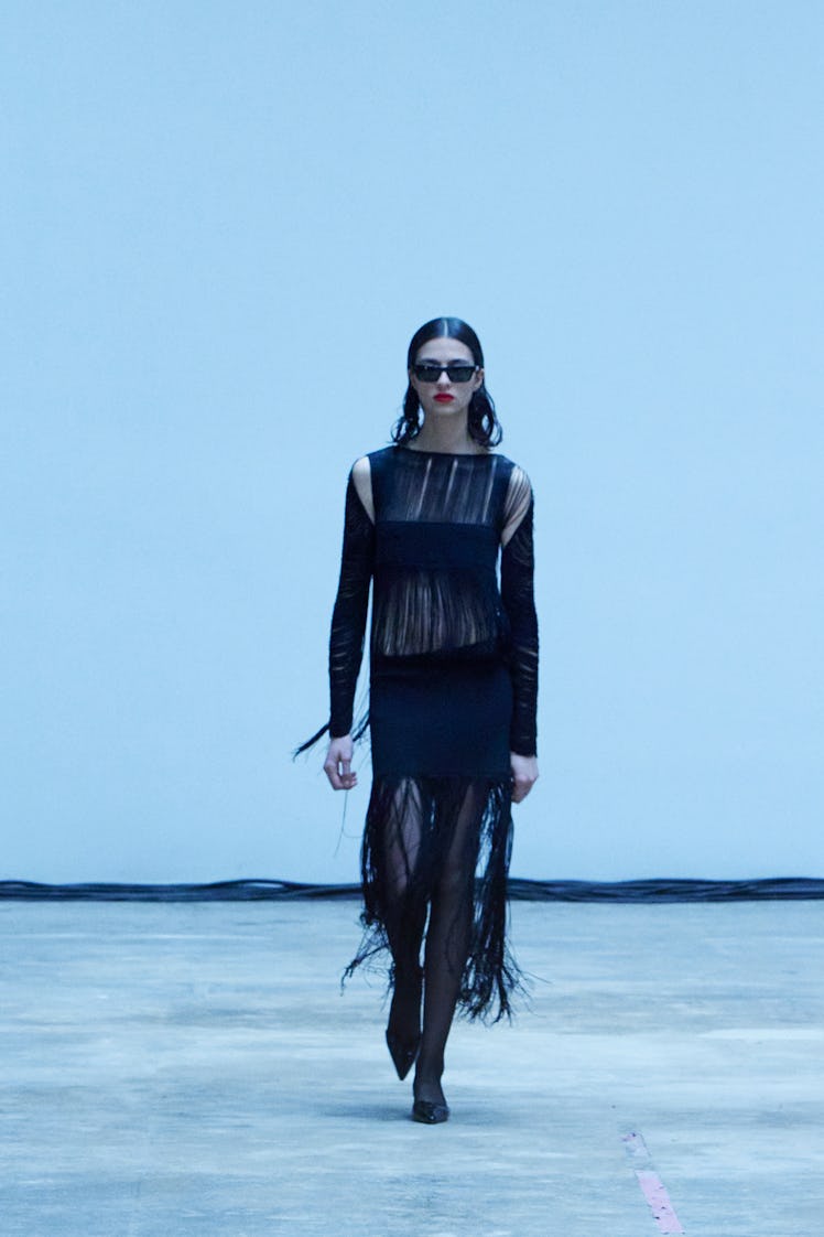 Model on the NY Fashion Week Fall 2022 runway in a Khaite black dress with rips