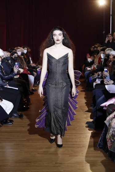 Model on the NY Fashion Week Fall 2022 runway in a Puppets and Puppets black dress with open shoulde...